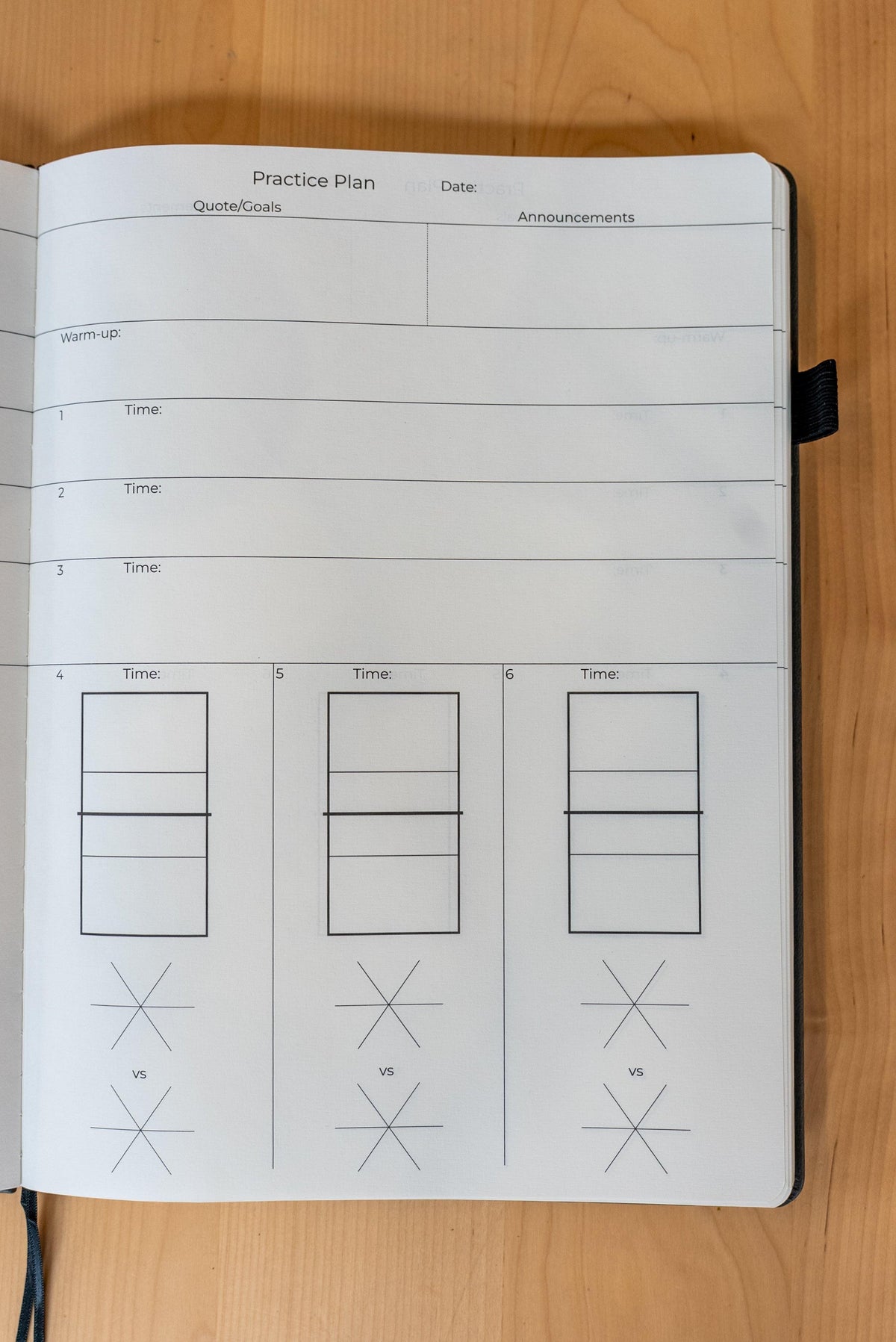 Balancetms The Coach's Notebook 2.0 open with lined pages, black cover, and branded logo, designed for coaching and note-taking.